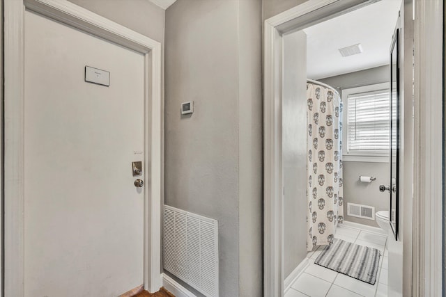 bathroom featuring tile patterned flooring and toilet