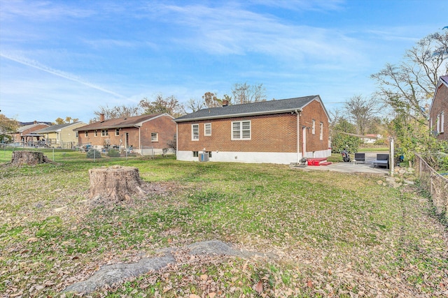 back of house featuring a lawn and a patio area