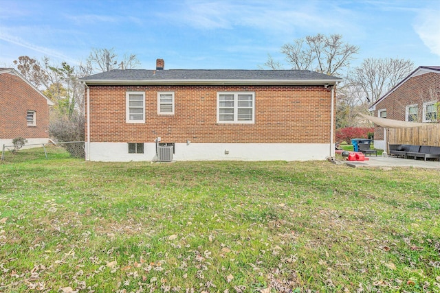 rear view of property featuring a lawn, a patio, and central AC