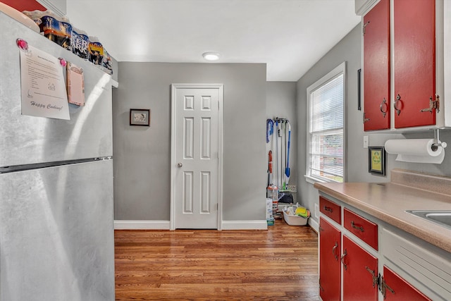 kitchen featuring stainless steel fridge and dark hardwood / wood-style flooring