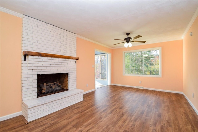 unfurnished living room featuring crown molding, ceiling fan, wood-type flooring, and a brick fireplace