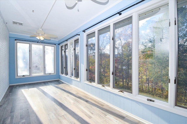 unfurnished sunroom with ceiling fan and a wealth of natural light