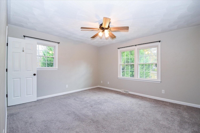 carpeted empty room featuring ceiling fan and a healthy amount of sunlight