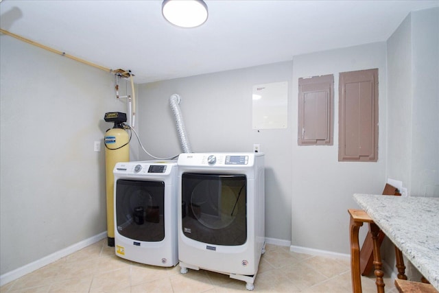 clothes washing area featuring washer and dryer, electric panel, and light tile patterned floors