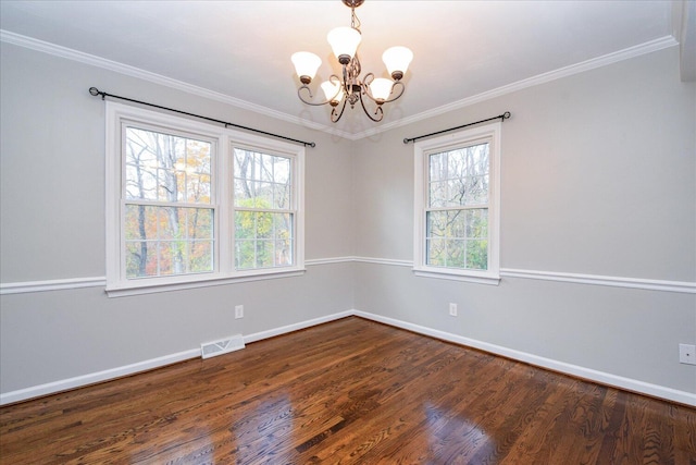 empty room featuring dark wood-type flooring, crown molding, and a chandelier