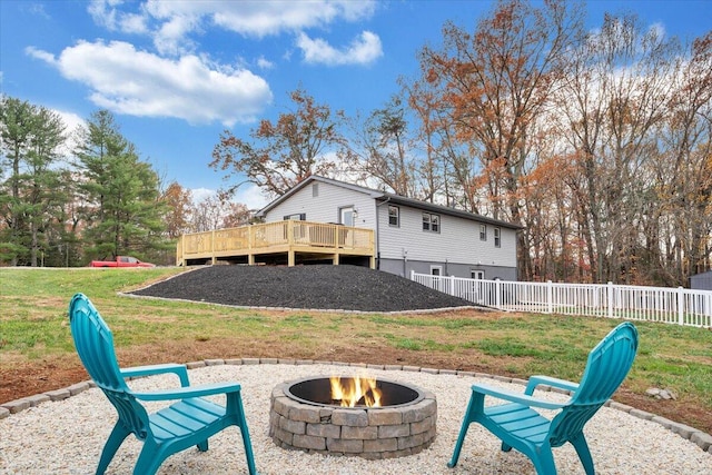 exterior space featuring a fire pit, a deck, and a lawn