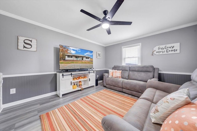 living room featuring hardwood / wood-style flooring, ceiling fan, and ornamental molding