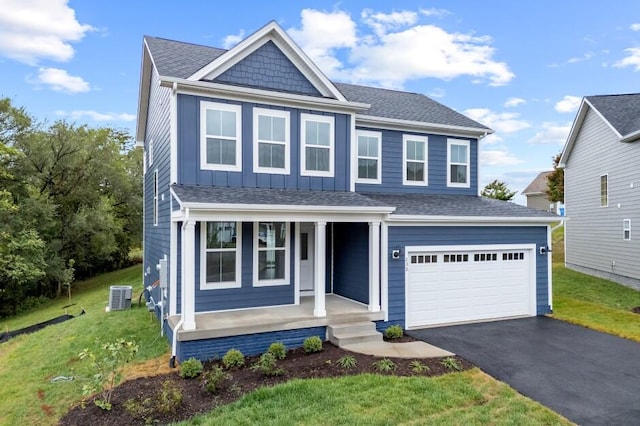 view of front of home featuring covered porch, central AC, and a front lawn