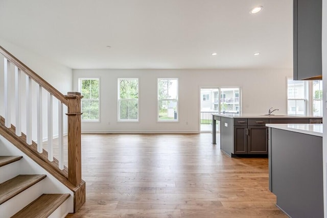 unfurnished living room featuring sink and light wood-type flooring