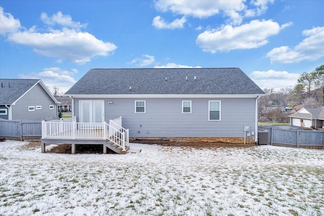 snow covered house featuring a deck and central AC unit