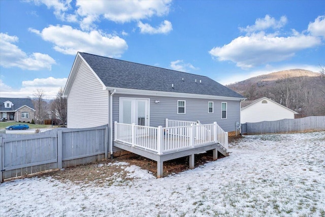 snow covered property featuring a deck with mountain view and central AC unit