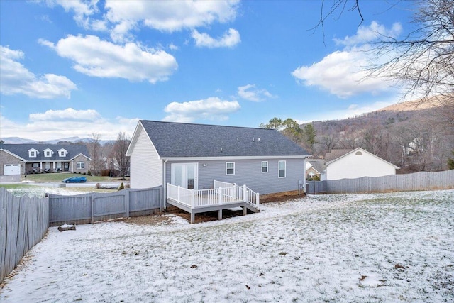 snow covered property featuring a deck with mountain view