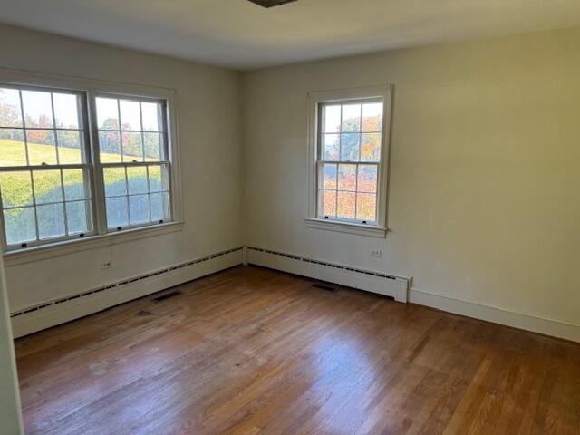 empty room with a baseboard radiator and wood-type flooring