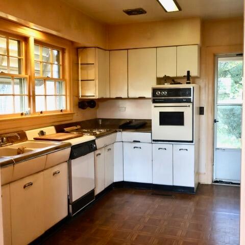 kitchen with white appliances, sink, and white cabinets