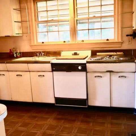 kitchen featuring dishwasher, white cabinets, and sink