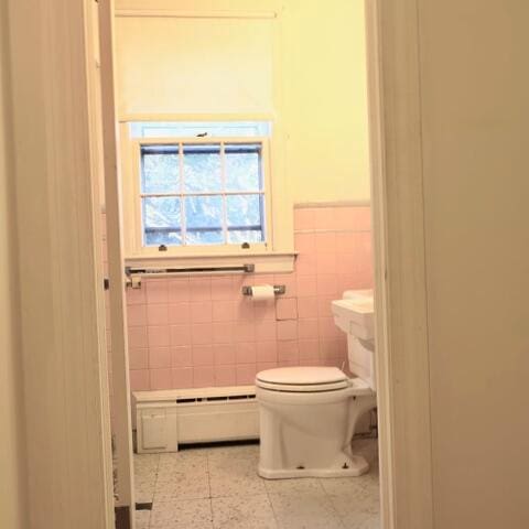 bathroom with toilet, tile walls, and tile patterned flooring