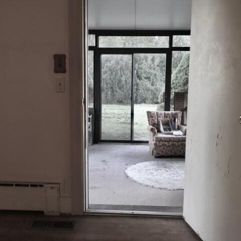 doorway with baseboard heating, expansive windows, and plenty of natural light