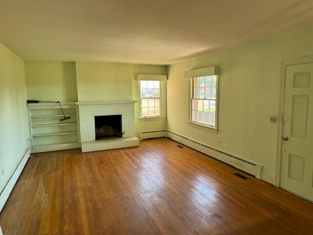 unfurnished living room featuring hardwood / wood-style floors and baseboard heating