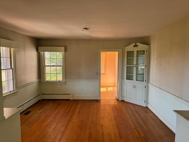 interior space with hardwood / wood-style floors and a baseboard heating unit