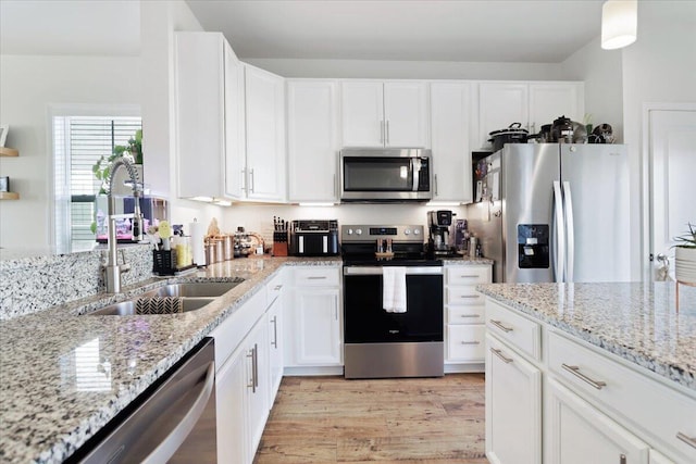 kitchen with white cabinetry, light hardwood / wood-style floors, and stainless steel appliances