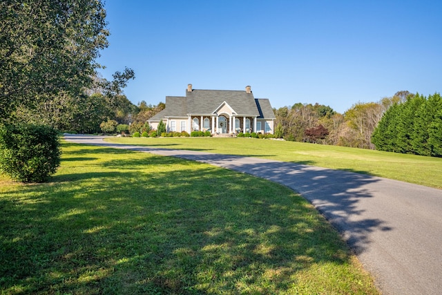 new england style home featuring a front lawn