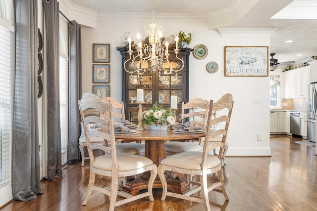 dining space with ornamental molding, dark wood-type flooring, and ceiling fan with notable chandelier