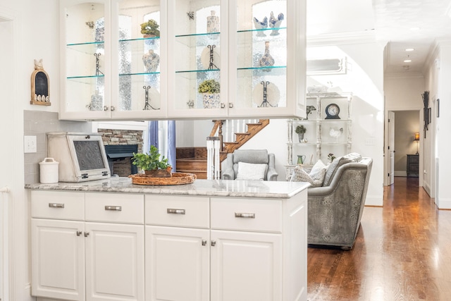 bar featuring crown molding, white cabinetry, light stone countertops, and dark wood-type flooring