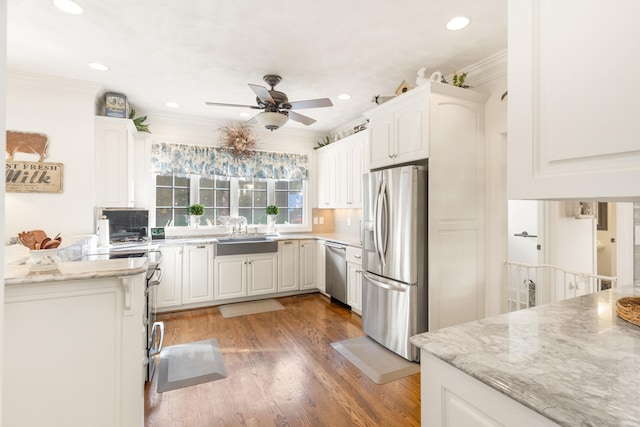 kitchen featuring sink, white cabinetry, appliances with stainless steel finishes, light stone counters, and dark hardwood / wood-style flooring