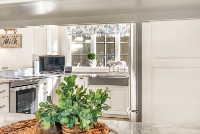 kitchen with white cabinetry, sink, and electric stove