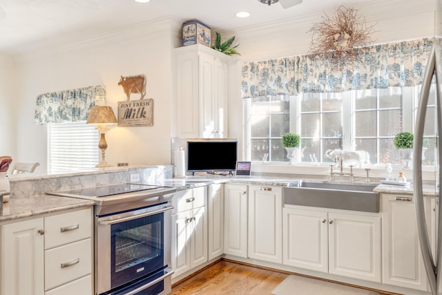 kitchen featuring ornamental molding, white cabinetry, stainless steel range with electric cooktop, and sink