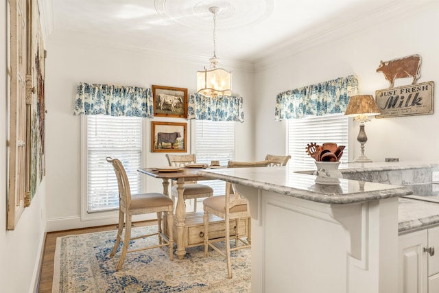 dining area with light hardwood / wood-style floors, a notable chandelier, and ornamental molding