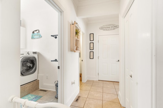 washroom with washer / dryer, crown molding, and light tile patterned floors