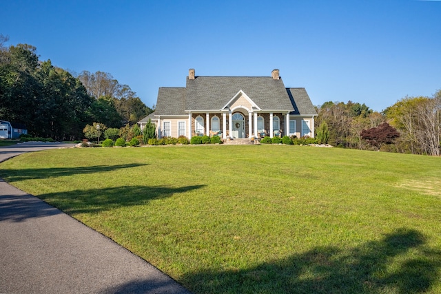 cape cod house featuring a front yard