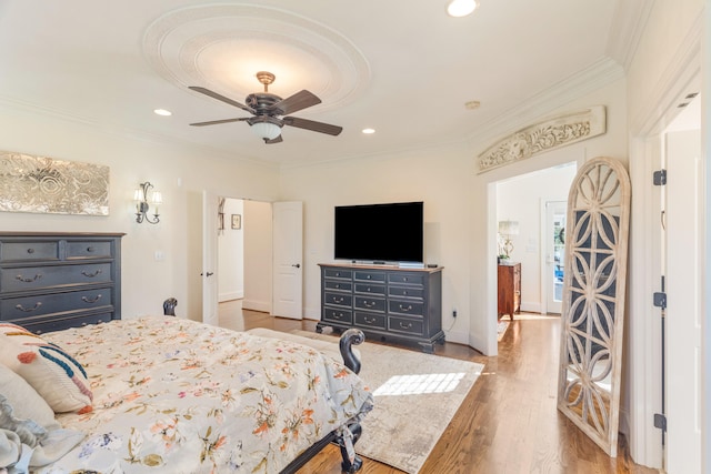 bedroom with ornamental molding, hardwood / wood-style floors, and ceiling fan