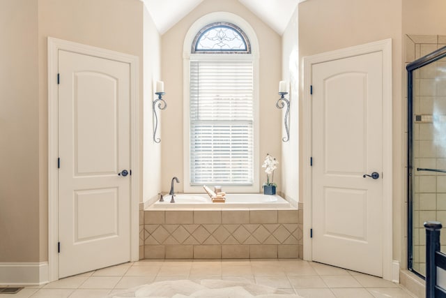 bathroom featuring tile patterned flooring, a healthy amount of sunlight, plus walk in shower, and vaulted ceiling