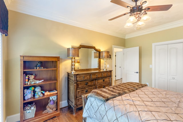 bedroom with hardwood / wood-style floors, crown molding, a closet, and ceiling fan