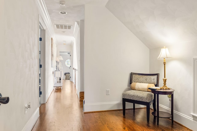 sitting room with hardwood / wood-style floors and vaulted ceiling