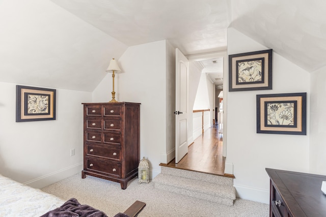 bedroom featuring lofted ceiling and light colored carpet