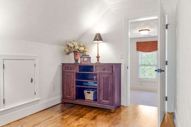 hallway with vaulted ceiling and wood-type flooring