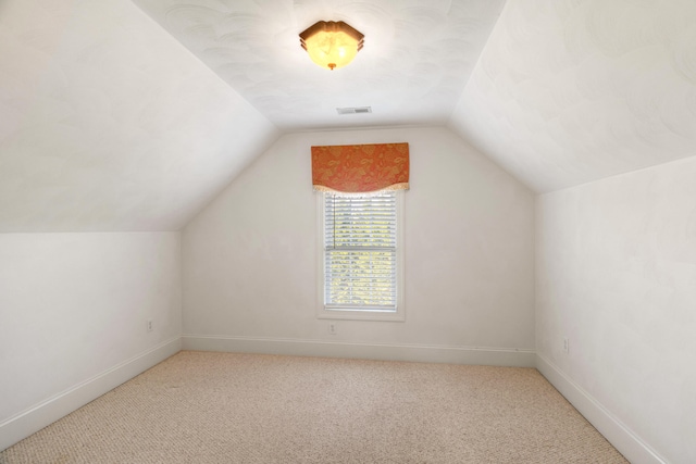 bonus room featuring vaulted ceiling and light colored carpet