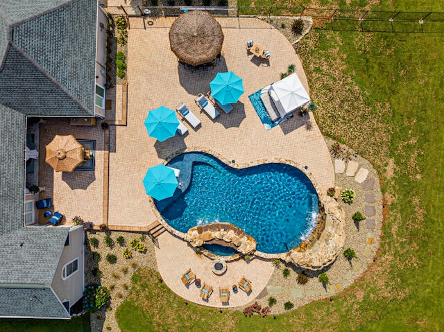 view of pool with a patio area and a lawn