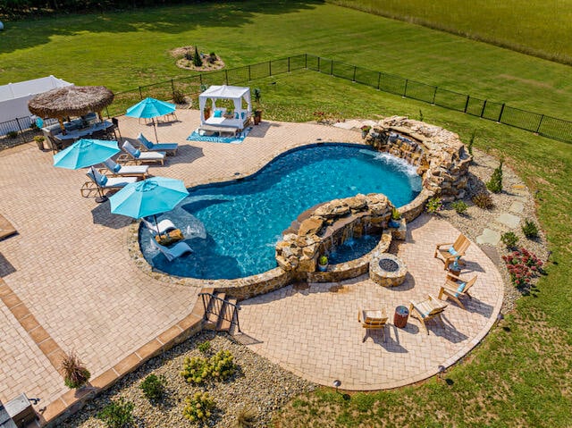 view of pool featuring a lawn, a gazebo, a patio, and a fire pit