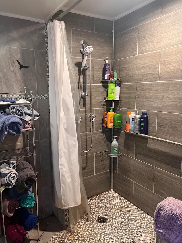 bathroom with a shower with curtain, tile patterned floors, and tile walls