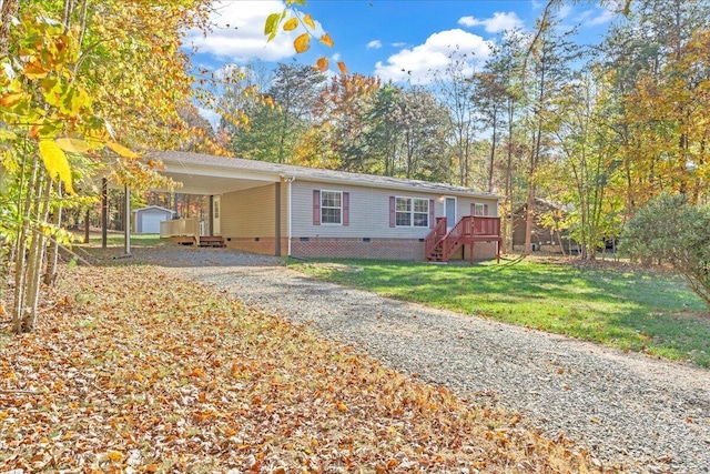 view of front facade featuring an outbuilding, a carport, a front lawn, and a wooden deck