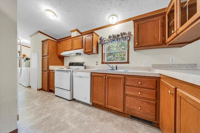 kitchen featuring a textured ceiling, white appliances, crown molding, sink, and washer / clothes dryer