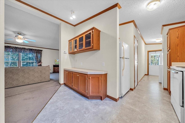 kitchen with stove, white refrigerator, ceiling fan, ornamental molding, and a textured ceiling