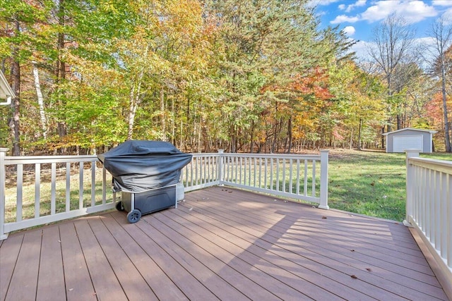 wooden deck with a lawn, a grill, and an outdoor structure