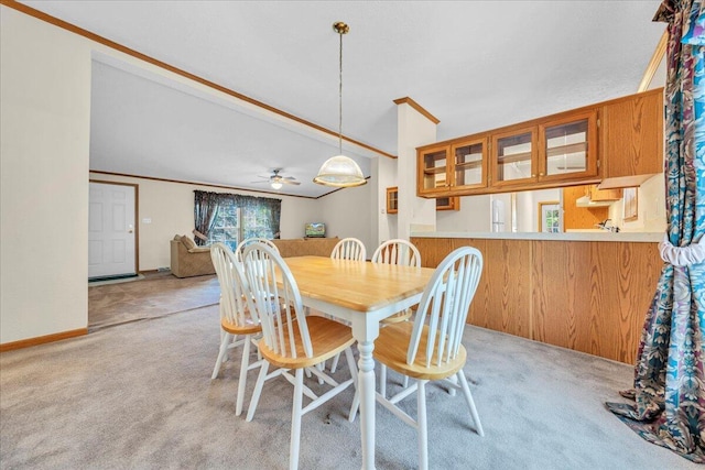 carpeted dining room featuring ceiling fan, wood walls, and ornamental molding