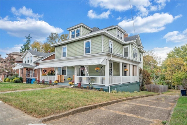 view of front of house featuring covered porch and a front lawn