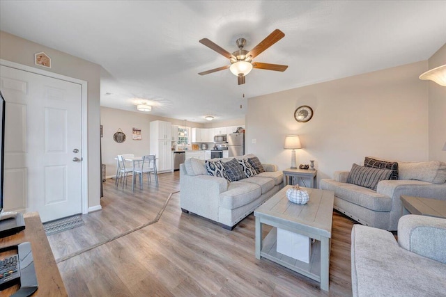 living room with ceiling fan and light hardwood / wood-style floors